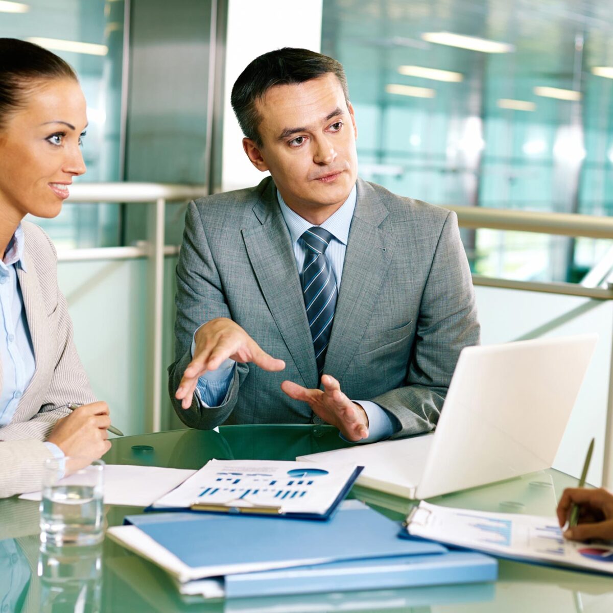 Females and male business professionals having discussion in an office meeting room.